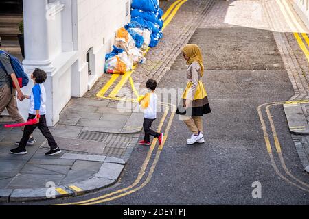 Londra, Regno Unito - 22 giugno 2018: Gente famiglia musulmana araba che cammina con la donna in abiti hijab sulla strada marciapiede con i bambini sulla strada Foto Stock