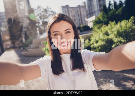 Ritratto fotografico di donna che prende il selfie tenendo con due mani all'aperto Foto Stock
