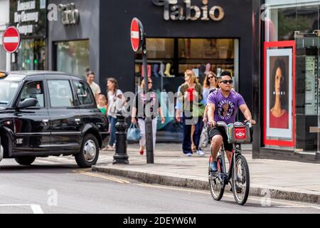 Londra, Regno Unito - 23 giugno 2018: Giovane uomo che noleggia bicicletta da Santander Cycles sulla strada di King's a Chelsea, Regno Unito con l Foto Stock