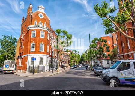 Londra, Regno Unito - 24 giugno 2018: Elystan Place strada nel quartiere West Chelsea con mattoni rossi bianco vernice terrazza a schiera casa cittadina, auto parcheggiate Foto Stock