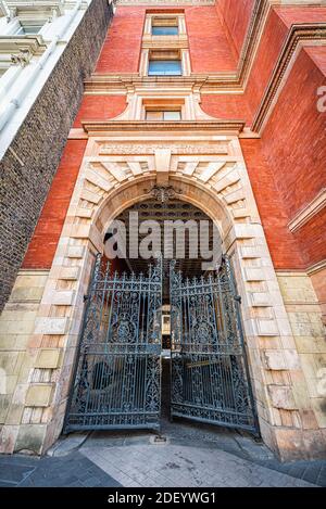 Londra, Regno Unito - 24 giugno 2018: Victoria and Albert art Museum l'ingresso dell'ala Henry Cole attraverso la porta in ghisa con l'architetto vittoriano in mattoni rossi Foto Stock