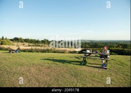 Le persone che godono il sole serale al Harrow View Point Foto Stock