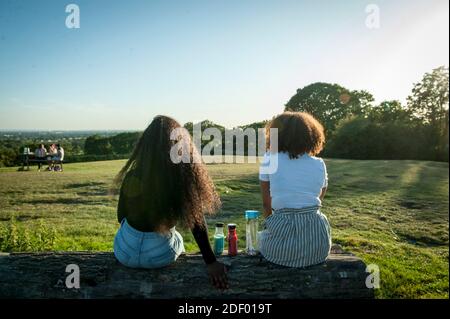 Le persone che godono il sole serale al Harrow View Point Foto Stock