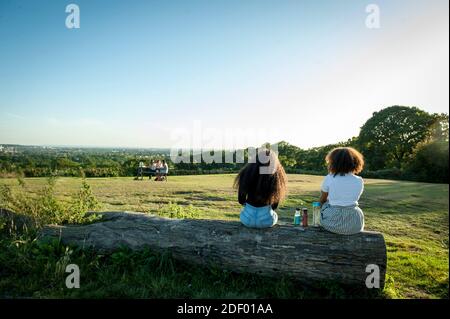 Le persone che godono il sole serale al Harrow View Point Foto Stock