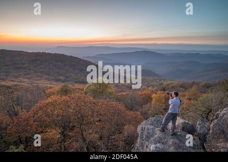 Un uomo scatta una foto al tramonto in autunno al monte Bearfence nel Parco Nazionale di Shenandoah, Virginia. Foto Stock