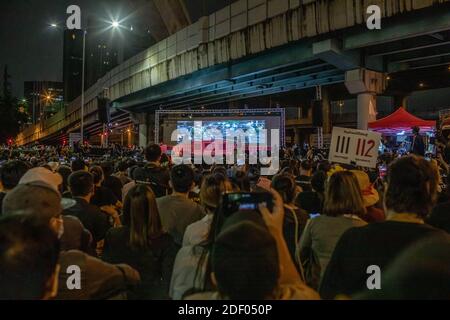 I manifestanti pro-democrazia ascoltano l'attivista Panusaya 'Rung' Sithijirawattanakul mentre guardano un film sul conflitto tra l'esercito thailandese e le Camicie rosse nel 2010 sono state 99 persone perse la vita, durante una manifestazione anti-governo nella capitale tailandese. Migliaia di manifestanti favorevoli alla democrazia si sono riuniti all'incrocio di Lad Phrao per chiedere le dimissioni del primo ministro tailandese Prayut Chan-o-cha e la riforma della monarchia. Il tema della protesta era il fatto che PM Prayut Chan-o-cha non è stato ritenuto colpevole dalla corte di rimanere nella casa dell'esercito dopo il suo ritiro come esercito Foto Stock