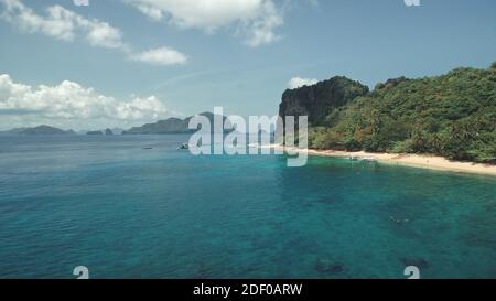 Vista aerea dell'isola del paradiso tropicale con spiaggia di sabbia bianca sulla costa della baia del mare. Alberi di verde, piante a isola collinare con barca a riva. Paesaggio epico estivo della natura delle Filippine, Asia Foto Stock