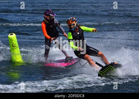 Due concorrenti femminili di Motorsurf che gareggiare intorno al marcatore di rotta. Foto Stock