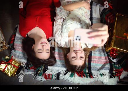 Sorridendo i giovani amici che prendono selfie con il loro telefono su uno serata invernale Foto Stock