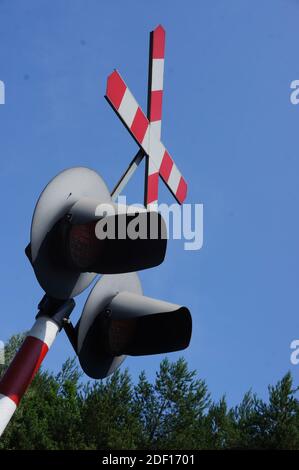 Un'immagine verticale ad angolo basso di un segnale luminoso del treno con un cielo blu chiaro sullo sfondo Foto Stock