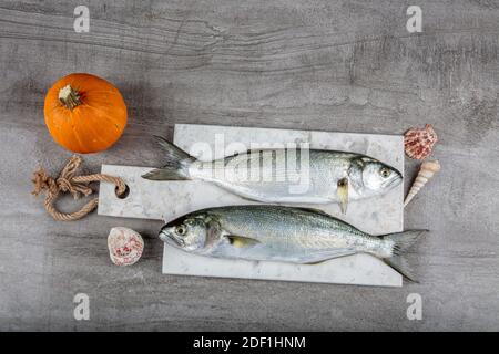 Bluefish grezzo. (Latino; Pomatomus Saltatrix). Pesce fresco con le verdure, condimento e limone, bluefish. Preparazione degli alimenti. Foto Stock