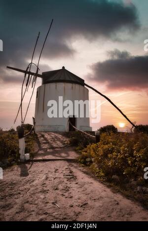 Bellissimo paesaggio. Mulino a vento con il tramonto spettacolare sullo sfondo. Foto Stock