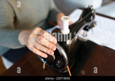 Le mani di vecchia donna usando una vecchia macchina da cucire Foto Stock