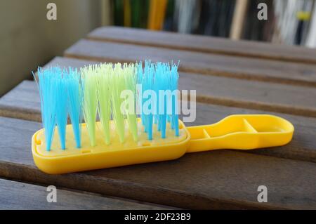 Un closeup di una scopa per mani giocattolo di plastica su un legno Foto Stock