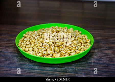 Un primo piano di cereali di grano soffiati ricoperti di miele in una piastra verde Foto Stock
