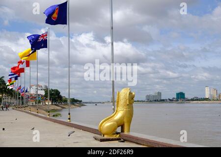 Cambogia Phnom Penh - passeggiata Riverside Park con internazionale nazionale bandiere e la statua del leone del guardiano dorato Foto Stock