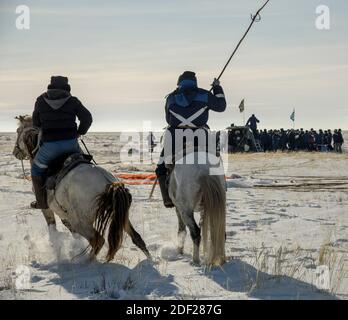 Due locali a cavallo arrivano al veicolo spaziale Soyuz MS-13 poco dopo essere atterrati in un'area remota vicino alla città di Zhezkazgan, Kazakistan, con la spedizione 61 membri dell'equipaggio Christina Koch della NASA, Alexander Skvortsov dell'agenzia spaziale russa Roscosmos, E Luca Parmitano dell'ESA (Agenzia spaziale europea) giovedì 6 febbraio 2020. Koch ritornò sulla Terra dopo aver registrato 328 giorni nello spazio --- il più lungo volo spaziale della storia da parte di una donna ---- come membro delle Expeditions 59-60-61 sulla Stazione spaziale Internazionale. Skvortsov e Parmitano ritornarono dopo 201 giorni nello spazio dove servirono come spedizione Foto Stock