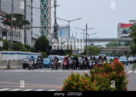 Giacarta, Indonesia - 25 ottobre 2020. Motociclisti e auto si fermavano al semaforo Foto Stock