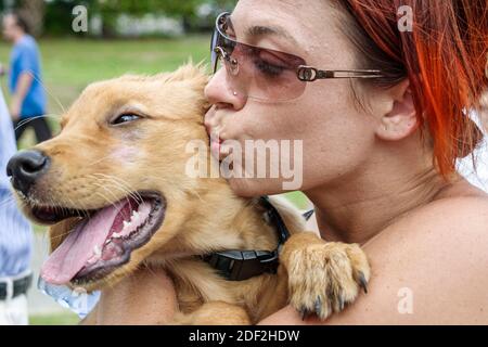 Miami Florida, Coconut Grove Peacock Park, ispanica donna femmina cane animale domestico tenendo baciare compagno, Foto Stock