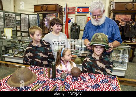 Alabama Athens Alabama Veteran's Museum & Archives, mostra collezione caschi munizioni conchiglie, ragazzi ragazza bambini bambini, cercare uomo guida explai Foto Stock