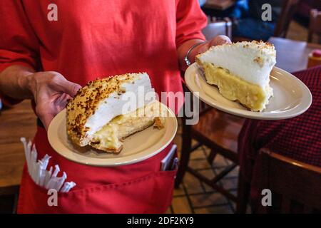 Alabama Decatur Big Bob Gibson BBQ ristorante, interno cameriera server che serve torta di crema di cocco fatta in casa, Foto Stock