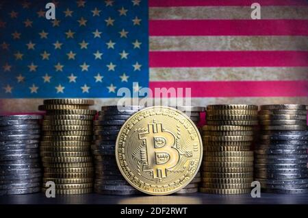 Bitcoin gettone davanti a monete e bandiera grugnosa degli stati uniti. Foto Stock