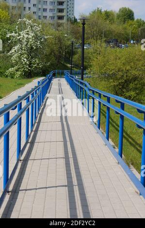 Una bella foto di una passerella circondata da metallo blu recinzioni nel parco Foto Stock