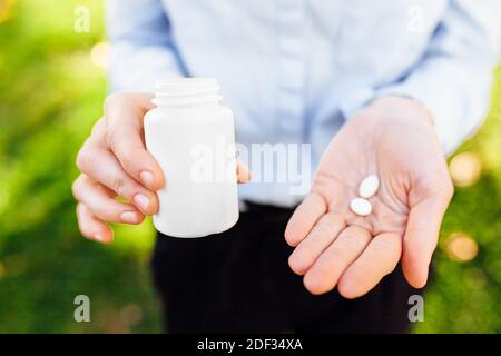 mani che tengono un vaso con pillole, closeup Foto Stock