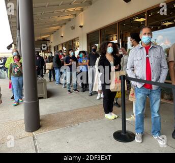 Allen, TX / USA - 27 novembre 2020: Vista ravvicinata delle persone che indossano la maschera e si allineano di fronte al negozio presso gli Allen Premium Outlets di Blac Foto Stock