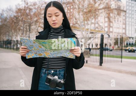 Giovane donna asiatica con una mappa. Foto Stock