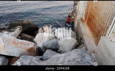Scappatoia per i rifugiati in fuga da una nave militare della Marina greca che serve da rifugio temporaneo per 400 a 600 migranti arrivati dall'inizio di marzo nel porto di Mutilene sull'isola di Lesbos; A seguito della decisione della Turchia di aprire le sue frontiere e della decisione della Grecia di interrompere la registrazione di nuove domande di asilo. Di conseguenza, questi migranti non sono registrati, in disparte dalle regole internazionali, e temono di essere deportati in Turchia. Senza registrazione non hanno alcuna esistenza legale: Il 15 marzo 2020, alcuni di loro hanno approfittato di un movimento di folla per tentare la fortuna. Loro Foto Stock