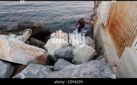 Scappatoia per i rifugiati in fuga da una nave militare della Marina greca che serve da rifugio temporaneo per 400 a 600 migranti arrivati dall'inizio di marzo nel porto di Mutilene sull'isola di Lesbos; A seguito della decisione della Turchia di aprire le sue frontiere e della decisione della Grecia di interrompere la registrazione di nuove domande di asilo. Di conseguenza, questi migranti non sono registrati, in disparte dalle regole internazionali, e temono di essere deportati in Turchia. Senza registrazione non hanno alcuna esistenza legale: Il 15 marzo 2020, alcuni di loro hanno approfittato di un movimento di folla per tentare la fortuna. Loro Foto Stock