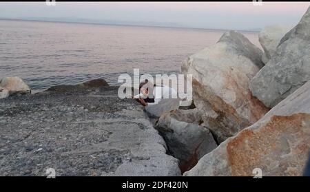 Scappatoia per i rifugiati in fuga da una nave militare della Marina greca che serve da rifugio temporaneo per 400 a 600 migranti arrivati dall'inizio di marzo nel porto di Mutilene sull'isola di Lesbos; A seguito della decisione della Turchia di aprire le sue frontiere e della decisione della Grecia di interrompere la registrazione di nuove domande di asilo. Di conseguenza, questi migranti non sono registrati, in disparte dalle regole internazionali, e temono di essere deportati in Turchia. Senza registrazione non hanno alcuna esistenza legale: Il 15 marzo 2020, alcuni di loro hanno approfittato di un movimento di folla per tentare la fortuna. Loro Foto Stock