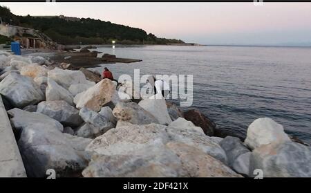 Scappatoia per i rifugiati in fuga da una nave militare della Marina greca che serve da rifugio temporaneo per 400 a 600 migranti arrivati dall'inizio di marzo nel porto di Mutilene sull'isola di Lesbos; A seguito della decisione della Turchia di aprire le sue frontiere e della decisione della Grecia di interrompere la registrazione di nuove domande di asilo. Di conseguenza, questi migranti non sono registrati, in disparte dalle regole internazionali, e temono di essere deportati in Turchia. Senza registrazione non hanno alcuna esistenza legale: Il 15 marzo 2020, alcuni di loro hanno approfittato di un movimento di folla per tentare la fortuna. Loro Foto Stock