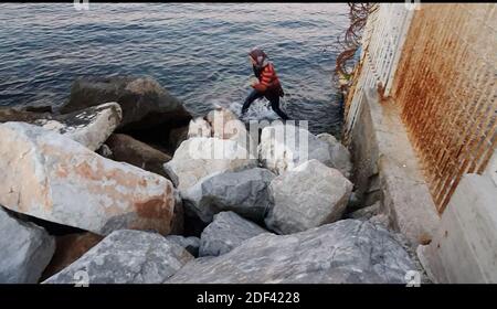 Scappatoia per i rifugiati in fuga da una nave militare della Marina greca che serve da rifugio temporaneo per 400 a 600 migranti arrivati dall'inizio di marzo nel porto di Mutilene sull'isola di Lesbos; A seguito della decisione della Turchia di aprire le sue frontiere e della decisione della Grecia di interrompere la registrazione di nuove domande di asilo. Di conseguenza, questi migranti non sono registrati, in disparte dalle regole internazionali, e temono di essere deportati in Turchia. Senza registrazione non hanno alcuna esistenza legale: Il 15 marzo 2020, alcuni di loro hanno approfittato di un movimento di folla per tentare la fortuna. Loro Foto Stock