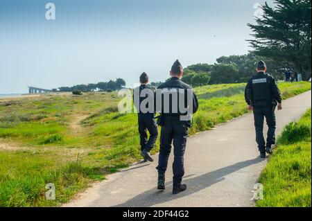 Gli ufficiali di gendarme controllano durante il controllo del traffico vicino a la Rochelle, Charentte-Maritime, Francia il 19 marzo 2020, mentre un blocco rigoroso entra in vigore in Francia per fermare la diffusione del COVID-19, causato dal romanzo coronavirus. Un rigido blocco che obbliga la maggior parte delle persone in Francia a rimanere a casa è entrato in vigore a mezzogiorno del 17 marzo 2020, vietando tutte le uscite, ma essenziali, nel tentativo di frenare la diffusione del coronavirus. Il governo ha detto che decine di migliaia di polizia saranno pattugliando le strade e l'emissione di multe di 135 euro (150 USD) per le persone senza una dichiarazione scritta che giustifica thei Foto Stock