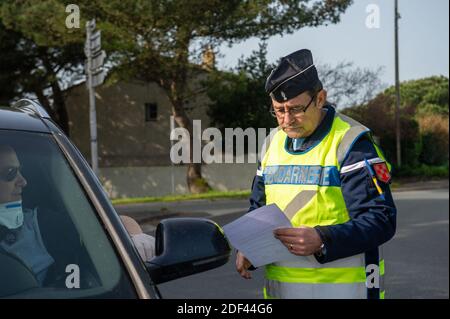 Gli ufficiali di gendarme controllano durante il controllo del traffico vicino a la Rochelle, Charentte-Maritime, Francia il 19 marzo 2020, mentre un blocco rigoroso entra in vigore in Francia per fermare la diffusione del COVID-19, causato dal romanzo coronavirus. Un rigido blocco che obbliga la maggior parte delle persone in Francia a rimanere a casa è entrato in vigore a mezzogiorno del 17 marzo 2020, vietando tutte le uscite, ma essenziali, nel tentativo di frenare la diffusione del coronavirus. Il governo ha detto che decine di migliaia di polizia saranno pattugliando le strade e l'emissione di multe di 135 euro (150 USD) per le persone senza una dichiarazione scritta che giustifica thei Foto Stock