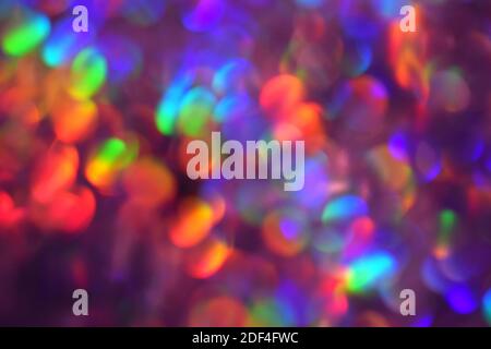 Sfondo natalizio, ghirlanda in sfocatura. Luminosi e festosi cerchi di luce arcobaleno creati in fotocamera e obiettivo bokeh. Le luci delle fate di Natale sono sfocate Foto Stock