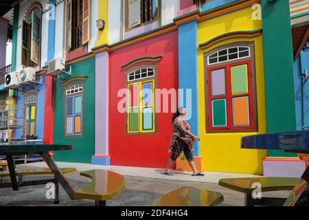 Una donna che cammina per la Casa multicolore di Tan Teng Niah, una ex villa del commerciante in Little India, Singapore Foto Stock