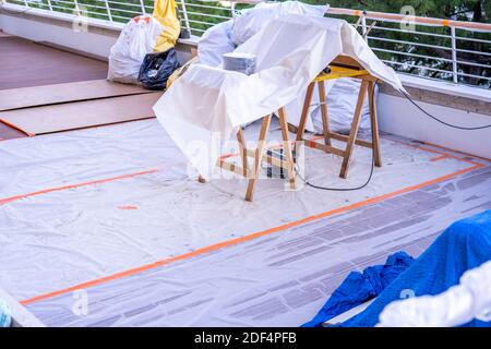 Costruzione di una terrazza in legno su un balcone. Una nuova terrazza in legno in costruzione. Sfondo della città. Foto Stock