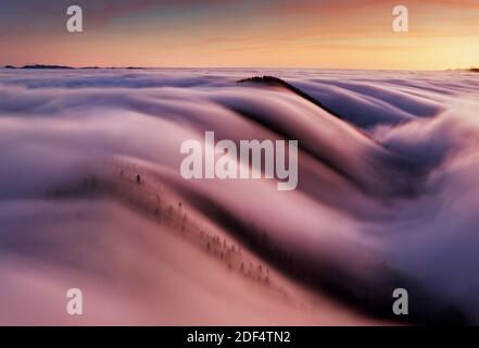 Bellissimo paesaggio, nebbia nebbiosa sulle pendici delle montagne, vista astratta sulle nuvole. Foto Stock