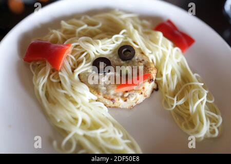 Spaghetti con Cutlet a forma di faccia su piastra Foto Stock