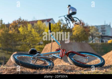 BMX in pista con salti sullo sfondo con case. Pista di salto per biciclette in città. Foto Stock