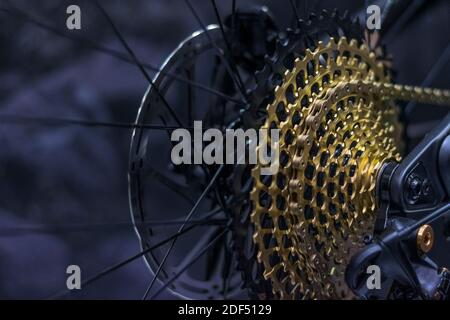 Moderna trasmissione in bicicletta con cassetta d'oro e molti ingranaggi. cassete per biciclette a 12 velocità. Foto Stock