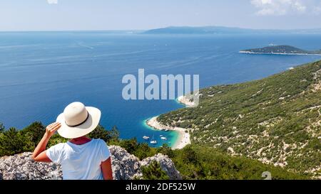 Giovane donna in piedi su un punto di osservazione sopra bella spiaggia, litorale, mediterraneo, una persona. Foto Stock