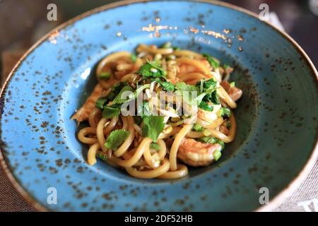 Noodle con pesce sul piatto nel ristorante Foto Stock