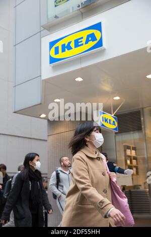 Le persone che indossano maschere per il viso passano davanti al negozio Ikea di recente apertura nel quartiere Shibuya, Tokyo. Foto Stock