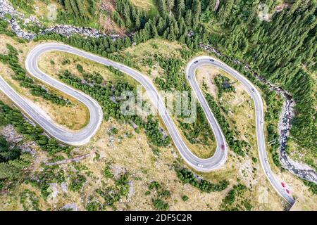 Strada tortuosa con molte curve, vista dall'alto. Fiume di montagna nelle vicinanze Foto Stock