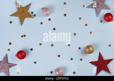 Modello di Natale fatto di palline dorate, argentate e rosse su sfondo blu. Concetto invernale. Disposizione piatta. Foto Stock