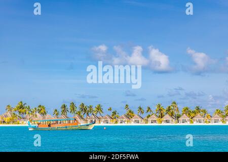 Perfetto isola tropicale paradiso spiaggia Maldive. Lungo molo e una barca tradizionale Dhoni. Estate viaggio turismo paesaggio, mare blu laguna spiaggia villa Foto Stock